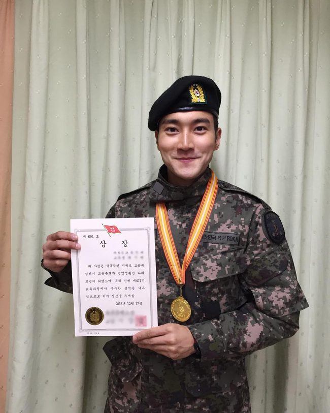 Siwon holding a certificate after his first month of training. 