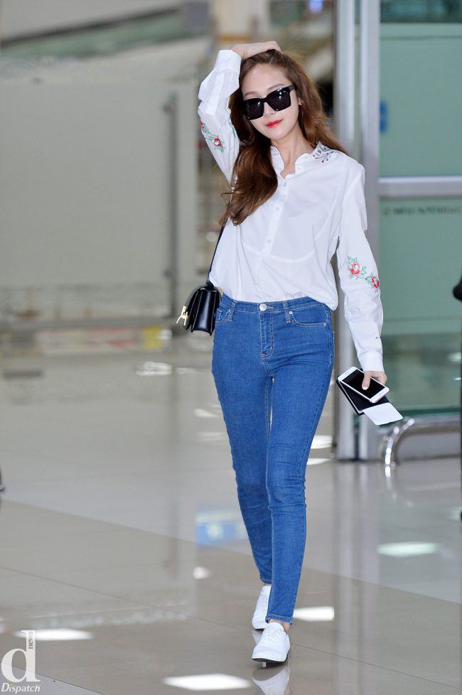 Jessica rocks a simple, but feminine outfit at the airport in light-blue jeans and a flowery white shirt. 