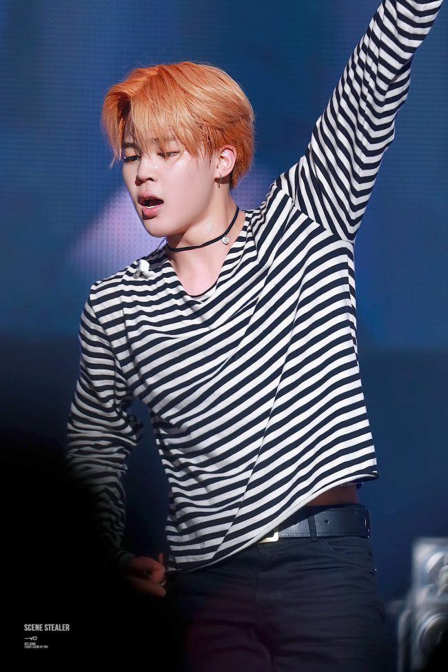 BTS' Jimin wears a striped top and accesorizes his outfit with a simple choker. 
