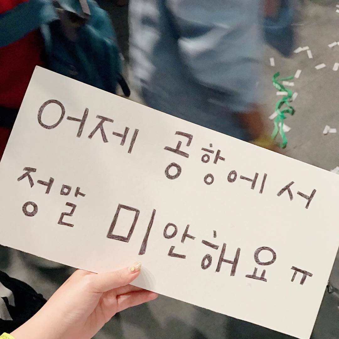 "Sorry [for what happened] at the airport" apology sign written by a fan
